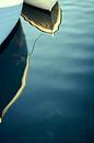 Der Bug eines kleinen Fischerboots spiegelt sich im Wasser von Michael Moser Miniaturansicht