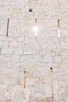 Die Sonne scheint durch eine Öffnung in der alten Mauer einer Burg in Pals, einer mittelalterlichen