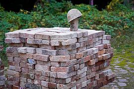 stacked bricks and old construction helmet on a building site