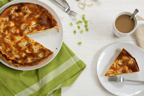 hausgemachter Kuchen oder Torte mit Rhabarber, ganz und serviert, grünes Küchentuch und eine Kaffeet