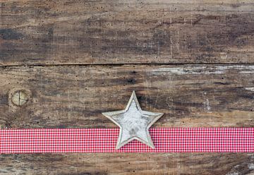 Christmas wood background with star shape on red ribbon by Alex Winter