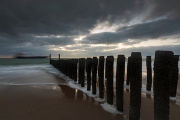 Hollandse wolkenlucht en golfbreker van houten palen langs de Zeeuwse kust van gaps photography