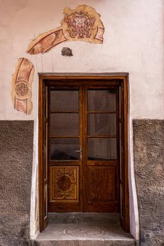 Karakteristieke houten deur met muurschildering van Dafne Vos
