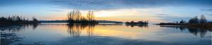 Sonnenuntergang über einem See mit kleinen Inseln am Ende eines Wintertages