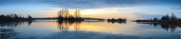 Zonsondergang over een meer met kleine eilandjes aan het eind van een winterdag van Sjoerd van der Wal Fotografie