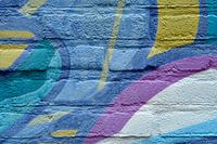 Abstraktes Bild eines Details einer Graffiti-Wand in blau-lila und gelben Farben