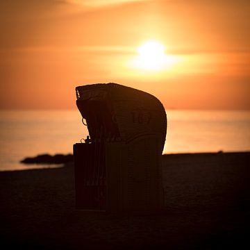 Strandkorb im Sonnenaufgang am Meer an der Ostsee