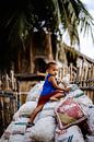Kind speelt op berg zakken, Filipijnen van Yvette Baur thumbnail