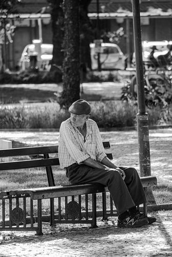 Oude man op bankje overdenkt het leven
