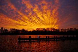 Zonsopkomst bij een steiger / Clouds lit up at sunrise.