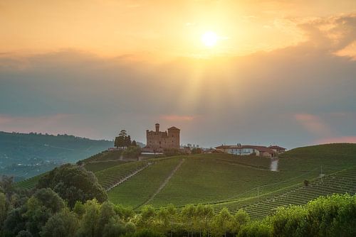 Het kasteel van Grinzane Cavour en de wijngaarden van de Langhe bij zonsondergang