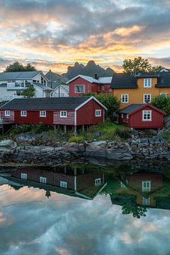 Spiegelende zonsndergang en karakteristieke huizen op de Lofoten van Axel Weidner