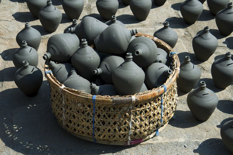 Mand en keramiekBhaktapur, Nepal: Pottenbakkersplein. Mand met traditionele Nepalese keramiek. Schep van Michael Semenov