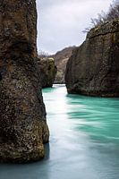 Blauw water tussen donkere rotsen