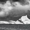 Majestueuze ijsbergen onder stormachtig lucht in zwart-wit van Chris Stenger