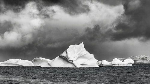 Icebergs majestueux sous un ciel d'orage en noir et blanc sur Chris Stenger