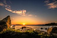 Zonsondergang aan de kust van Griekenland met strand en stenen en planten van Fotos by Jan Wehnert thumbnail