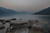 Avondschemer Lago Maggiore. Rotsblokken, water, nevel en bergen