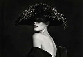 Woman wearing a wide-brimmed feathered hat in black and white