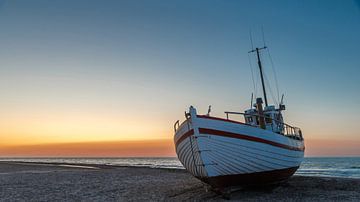 Visserboten op het Deense strand bij zonsondergang.