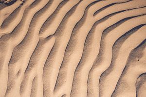 Sandmuster am Strand durch den Wind, der über den Sand bläst