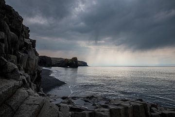 Bedrohliche Wolkendecke über den Felsen an der isländischen Küste von Ellen Snoek