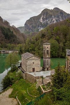 Kleine kerk aan groen stuwmeer tussen de Toscaanse heuvels van Joost Adriaanse