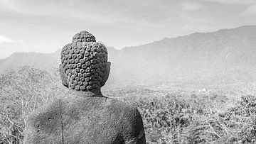 Boeddhabeeld kijkt over het dal Borobudur Indonesië zwart wit van John Stijnman