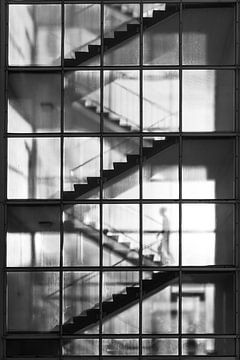 Duitsland, Berlijn, een jongen loopt de trap op in een trappenhuis waar het licht doorheen schijnt van Anke de Groot