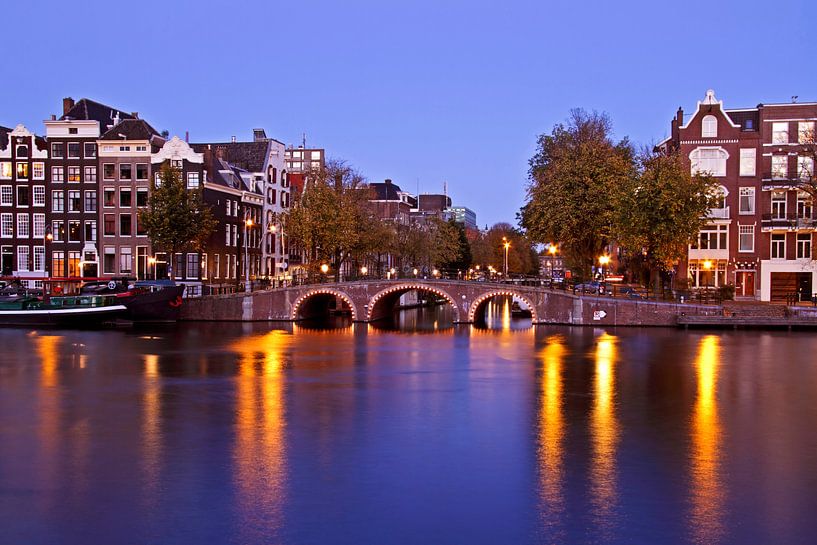 Amsterdam bij avond aan de Amstel in Nederland par Eye on You