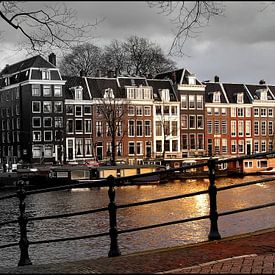 Amsterdam, zonnestraal op een sombere Amstel by Robert-Jan van Lotringen