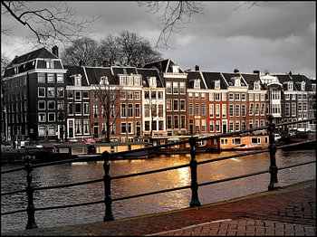 Amsterdam, zonnestraal op een sombere Amstel