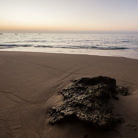 Zonsondergang op strand met steen van Marijn Goud