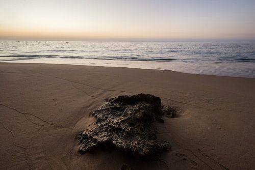 Zonsondergang op strand met steen van Marijn Goud