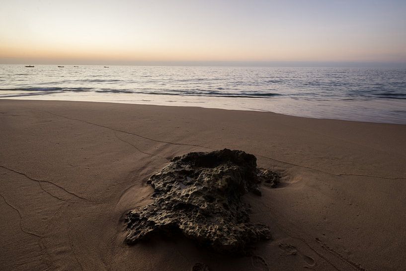Zonsondergang op strand met steen van Marijn Goud