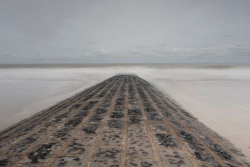 Sea view over a small stone pier on the Belgian North Sea coast