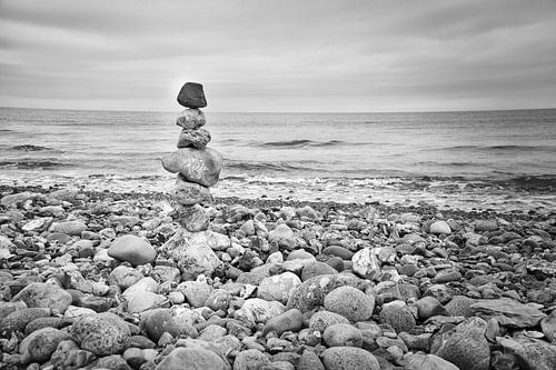 Stenen piramide op het strand met uitzicht op zee. Deense kust. Scandinavisch landschap