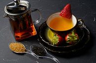 Thé noir avec fraise dans une tasse et un pot en verre avec du thé par Babetts Bildergalerie Aperçu