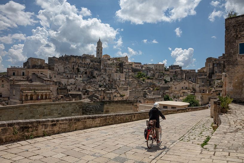 View of old town of Matera, Italy with cyclist in foreground by Joost Adriaanse