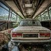 Oude vervallen auto Lada in een lege bus. van Sven van der Kooi (kooifotografie)