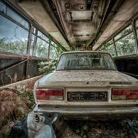 Oude vervallen auto Lada in een lege bus. van Sven van der Kooi (kooifotografie)