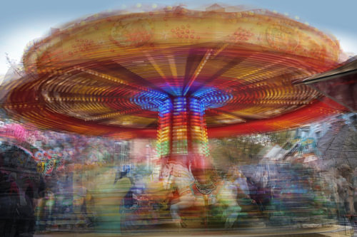 Kinderkarussell in Bewegung auf einem Weihnachtsmarkt, mehrere lange e