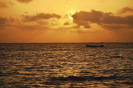Bateau dans la mer au coucher de soleil