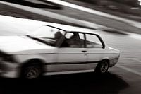 Weißer BMW-Oldtimer auf der Rennstrecke