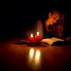 Reading with candle light by Anton de Zeeuw