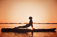 Yogapose comme silhouette au coucher du soleil sur une planche de surf par Mijke Bressers Aperçu