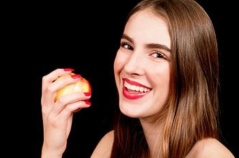 Junge Frau isst einen Apfel