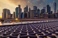 De skyline van New York vanaf de Brooklyn Bridge bij zonsondergang