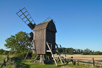Vieux moulin à vent en bois dans un paysage idyllique sous un ciel bleu