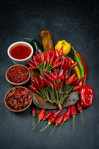 Hete pepers met kruiden op een donkere lei